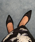 Black pointed-toe shoes with lace details worn with a black kebaya kurung  with white floral embroidery.
